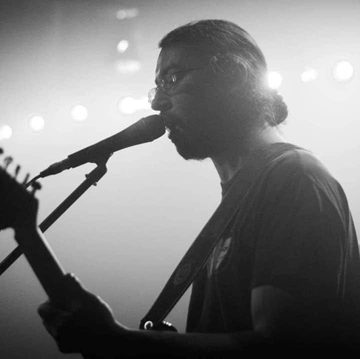 Cade Howard singing into a microphone on stage